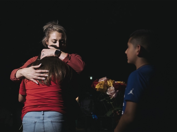A woman embraces a child outside Willie de Leon Civic Center in Uvalde, Texas